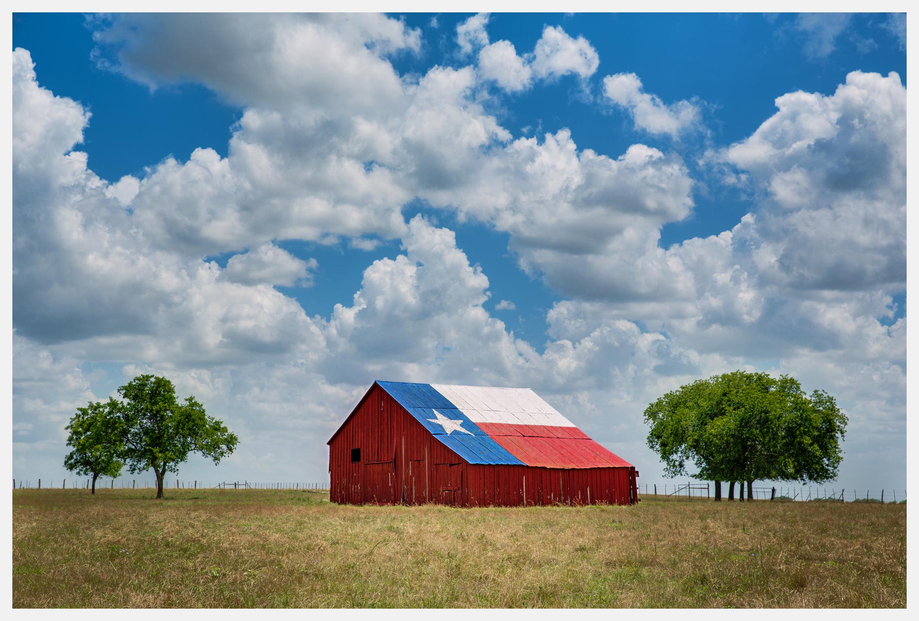Texas Barn With Lone Star Flag and White Clouds